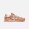 A single Women's Nano X4 Training Shoe by Reebok in peach with white accents and a patterned heel is shown in side profile on a plain white background—this lightweight, breathable design suits active lifestyles.