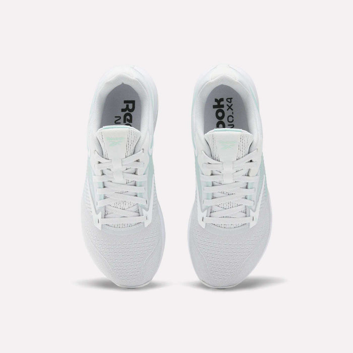 A pair of white Reebok Women's Nano X4 Training Shoes seen from above, featuring breathable mesh uppers, laces, black Reebok branding on the insoles, and Floatride Energy Foam cushioning for comfort.