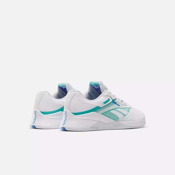 A pair of Reebok Women's Nano X4 Training Shoes in white with teal and blue accents, shown from an angled view highlighting the side and back. These lightweight, breathable shoes feature mesh detailing plus branding on the heel and tongue.