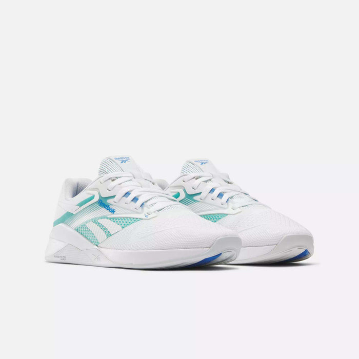 The Reebok Women's Nano X4 Training Shoes are white with teal and light blue side and heel accents, featuring the Reebok logo, displayed on a plain white background.