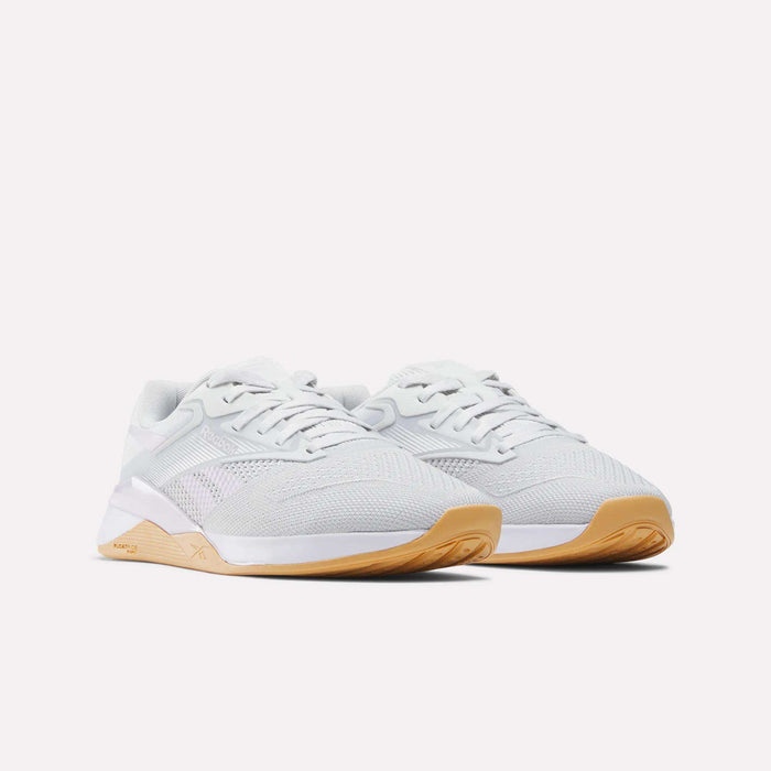The Reebok Women's Nano X4 Training Shoes feature breathable mesh uppers, white laces, and light brown gum soles with Floatride Energy Foam, shown on a white background.