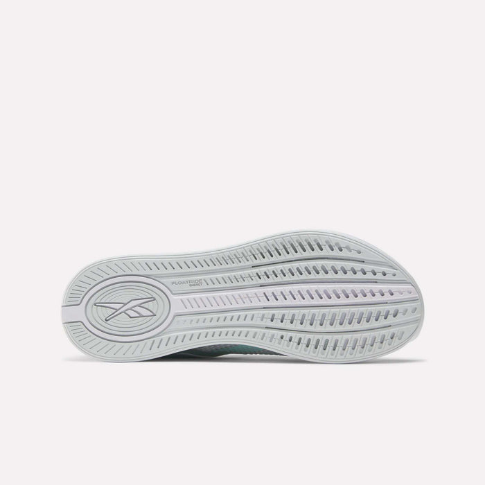 The image shows the sole of the Reebok Women's Nano X4 Training Shoes, featuring a wavy tread pattern with multiple grooves and a logo on the left side. The light gray sole is made with Floatride Energy Foam.