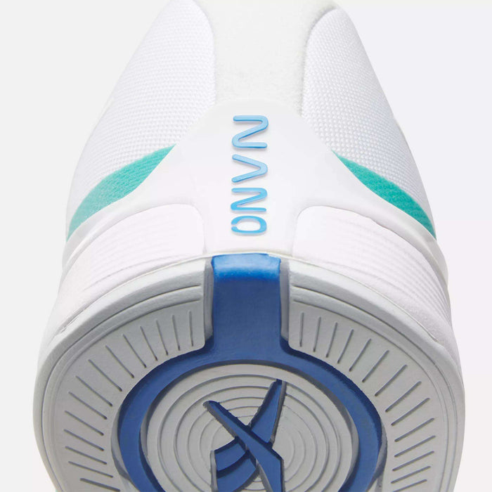 Close-up of the sole and toe of a white Reebok Women's Nano X4 Training Shoe featuring turquoise and blue accents. "NANO" appears in blue near the toe, and a circular sole pattern provides extra grip.
