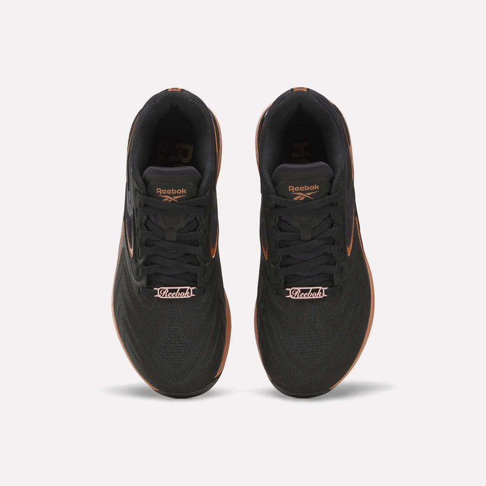 Top view of Reebok Women's Nano X5 Edge Training Shoes in black with orange accents and “Victoria” on the laces—ideal for your next HIIT class.