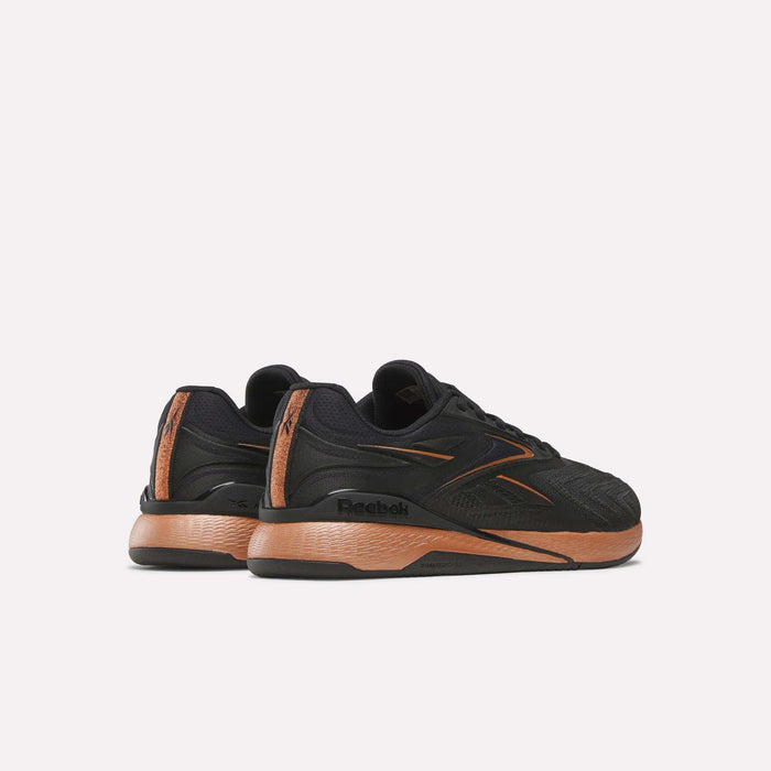 The Reebok Women's Nano X5 Edge Training Shoes in black with orange accents are displayed from the back and side on a plain light background—ideal for your next HIIT class.