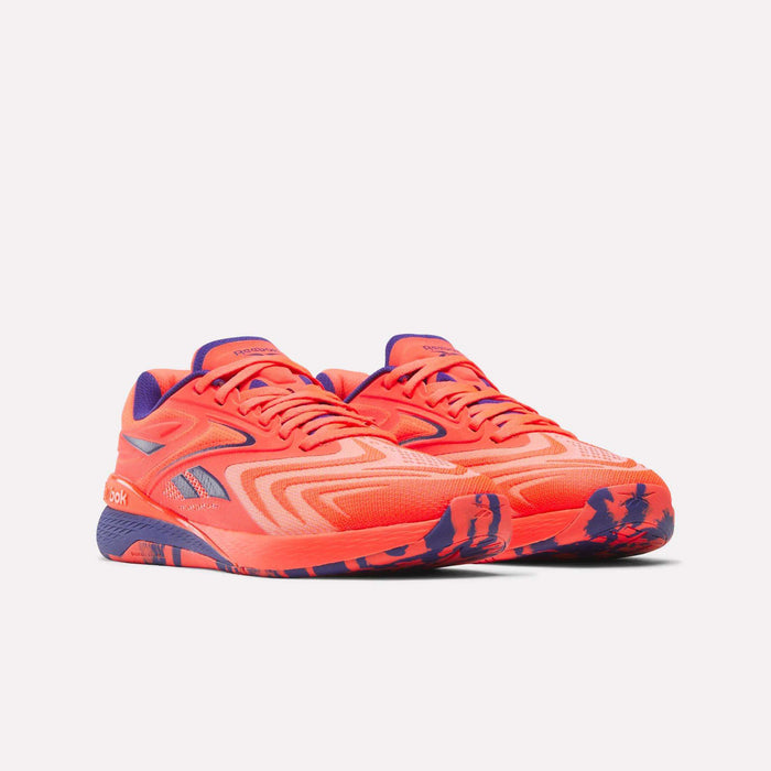 Reebok Women's Nano X5 Edge Training Shoes in bright orange with purple accents, geometric pattern, and a marbled purple-orange sole—perfect for HIIT. Both sneakers are shown side by side on a plain white background.