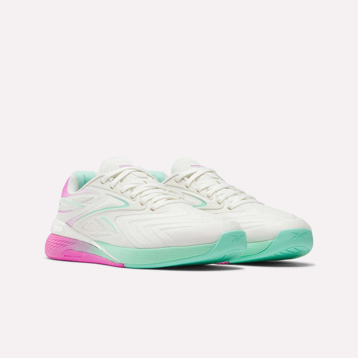 Reebok Women's Nano X5 Edge Training Shoes in white with mint green front soles, pink heel soles, and matching accents—perfect for HIIT—are shown on a white background.