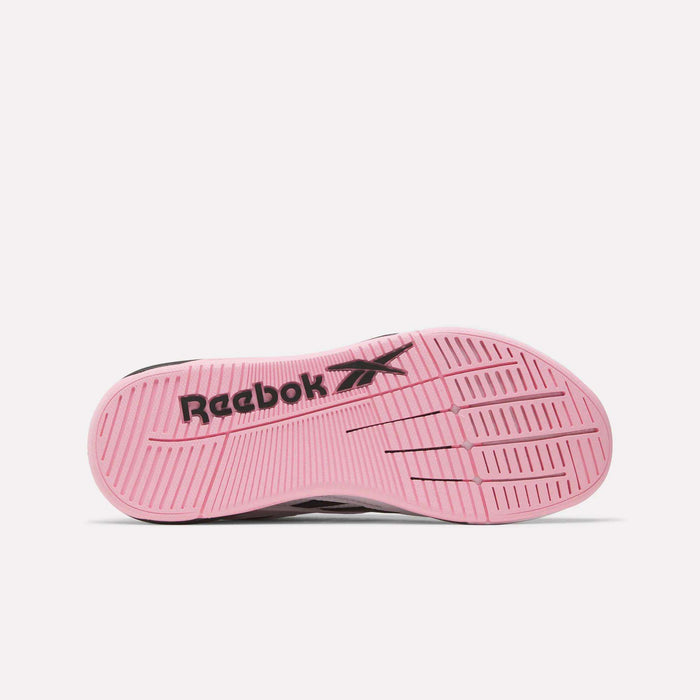The image shows the sole of a Reebok Women's Nano X5 Edge Training Shoe, with a pink base, grooved patterns, and a black Reebok logo and vector symbol across the middle.