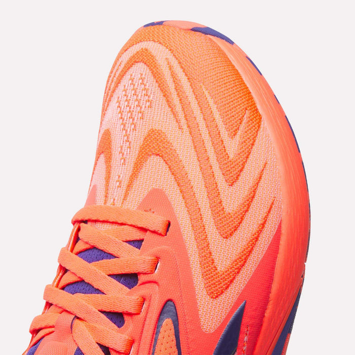 Close-up of the toe area of Reebok Women's Nano X5 Edge Training Shoes in bright orange, showcasing their wavy mesh upper and matching laces—ideal for powering through your next HIIT class.