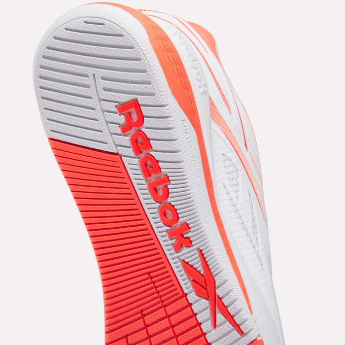 Close-up of the sole of Reebok Women's Nano X5 Edge Training Shoes in white and bright red, highlighting the brand logo and textured grip pattern designed for HIIT workouts.
