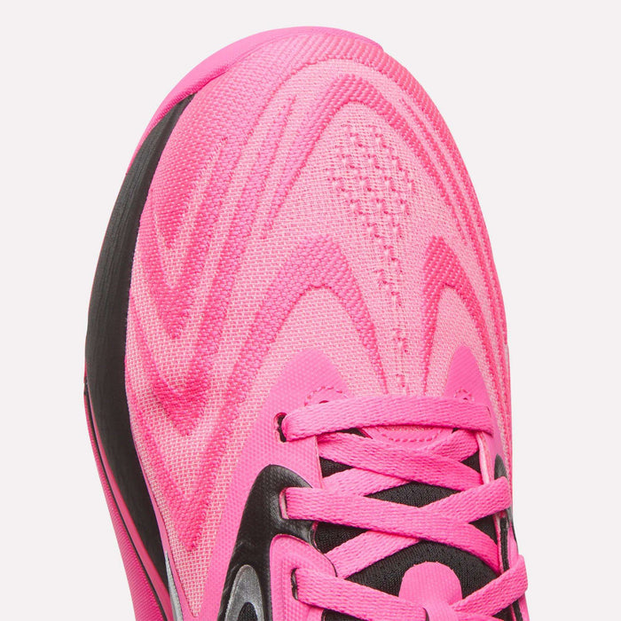 Close-up of the toe and laces of a bright pink Women's Nano X5 Edge Training Shoe by Reebok, featuring black accents and wavy mesh patterns.