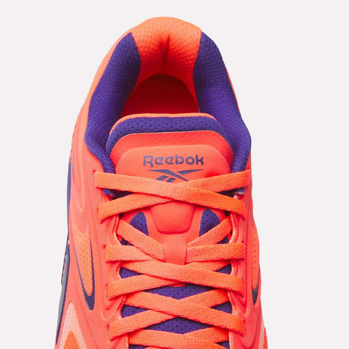 Top view of Reebok Women's Nano X5 Edge Training Shoe in bright orange and purple with orange laces, purple inner lining, and the Reebok logo on the tongue—ideal for your next HIIT class.