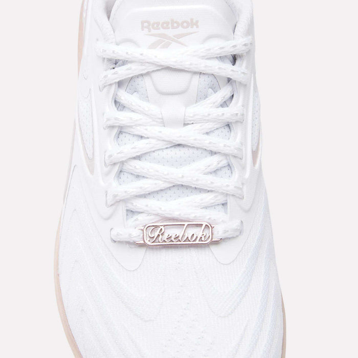 Close-up of the Women's Nano X5 Edge Training Shoes by Reebok, featuring a white textured upper, detailed laces, and a metallic logo tag—ideal for HIIT or daily workouts.