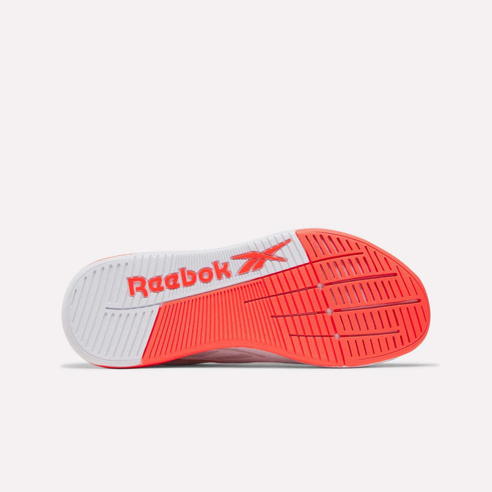 The image displays the sole of Reebok Women's Nano X5 Edge Training Shoes, with a white base, red section, and the Reebok logo and vector in red. The unique tread patterns provide superior grip, making them ideal for women's HIIT workouts.