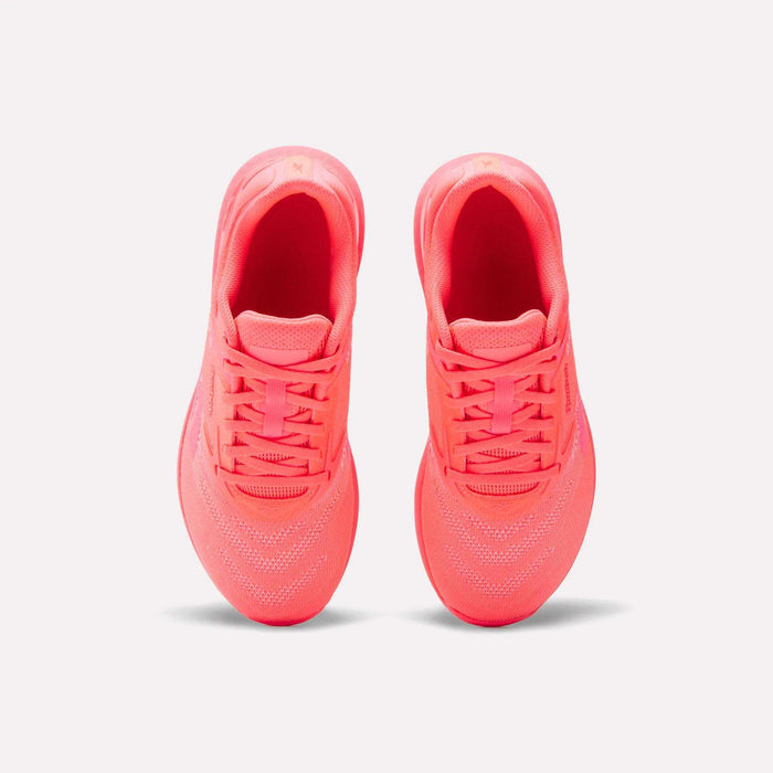 A pair of Reebok Women's Nano X5 Training Shoes in neon pink is shown from above, highlighting the tops, laces, and mesh details against a plain white background.