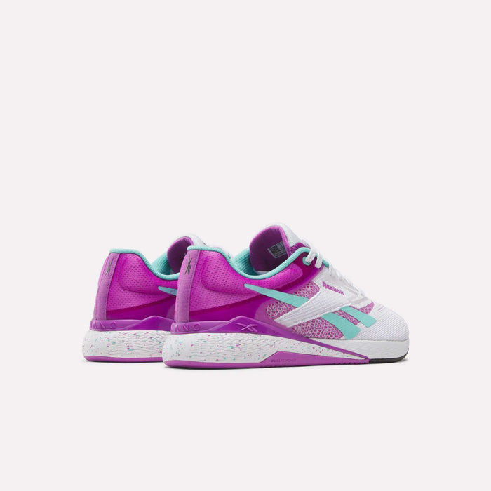 The Reebok Women's Nano X5 Training Shoes are low-top, comfortable sneakers in purple, teal, and white with teal accents and speckled midsoles, shown from back and side angles on a white background.