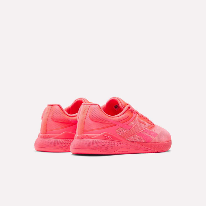 A pair of Reebok Women's Nano X5 Training Shoes in bright pink, featuring mesh uppers and textured soles, displayed at an angle on a plain white background.