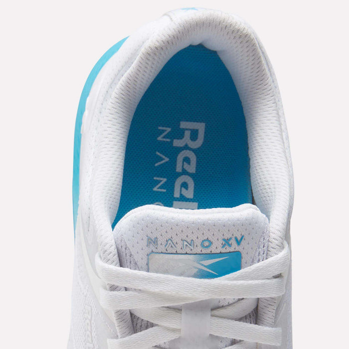 Close-up top view of the Reebok Women's Nano X5 Training Shoes, featuring a white design with blue interior accents and NANO X5 on the tongue. The insole shows the Reebok logo in white on blue, offering a stylish choice for women's footwear.