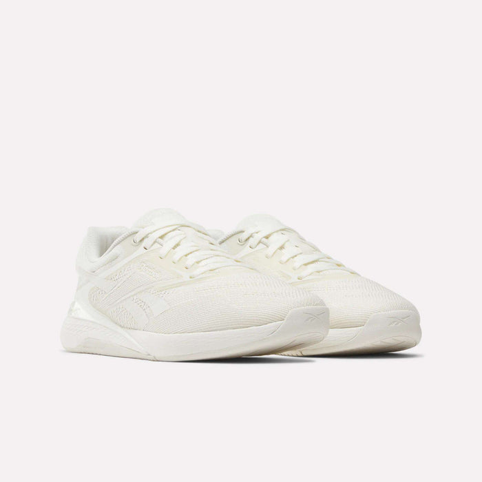 A pair of Reebok Nano X5 Women's Training Shoes in white, featuring a textured mesh upper, lace-up design, and cushioned soles, shown on a plain white background.