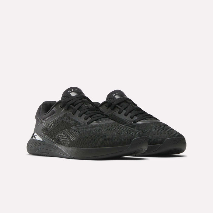 A pair of Women's Nano X5 Training Shoes by Reebok in black, featuring mesh uppers and textured details, displayed at an angle on a light background.