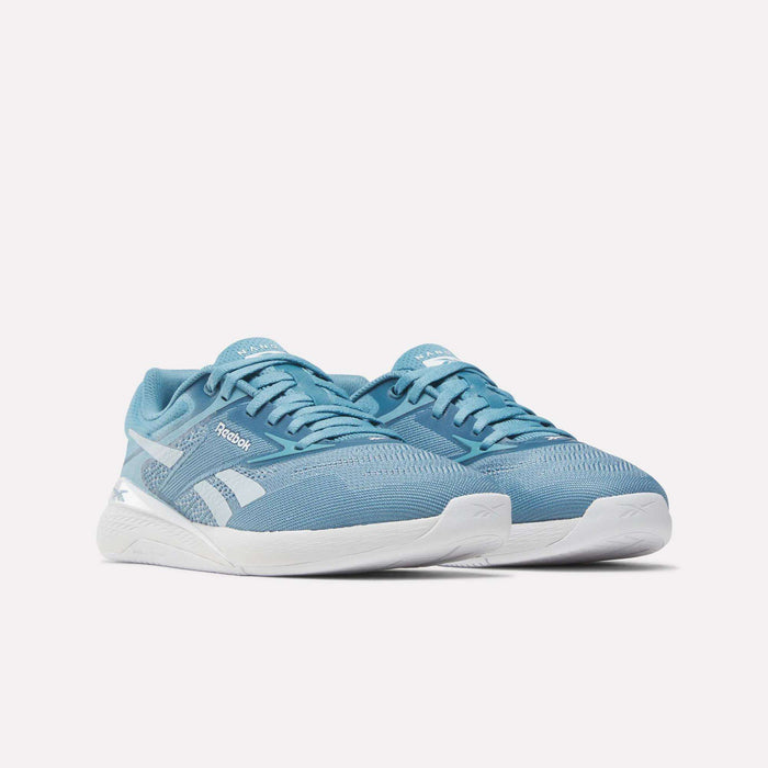 A pair of Reebok Nano X5 Women's Training Shoes in light blue with white soles and white Reebok logo details, designed for optimal comfort, displayed on a plain white background.