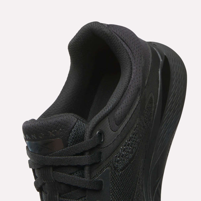 Close-up of the Reebok Women's Nano X5 Training Shoe in black, highlighting its heel, padded collar, laces, and textured midsole against a white background—ideal for women’s shoe collections.