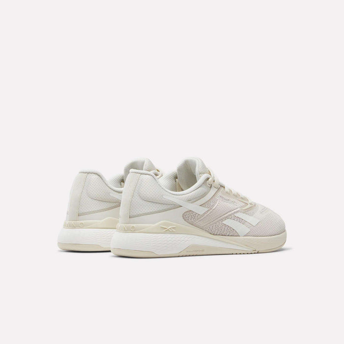 A pair of Women's Nano X5 Training Shoes by Reebok in beige and white, featuring mesh and synthetic uppers, shown from the back and side on a plain white background.