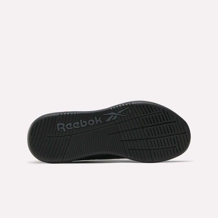 The image displays the black sole of the Reebok Women's Nano X5 Training Shoes, featuring the Reebok name and logo embossed at the center. Grooves and textured patterns provide grip, shown against a plain white background.