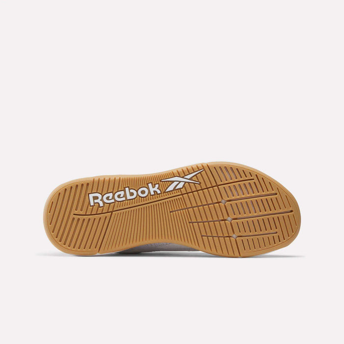 The image shows the outsole of the Women's Nano X5 Training Shoes by Reebok, with a brown rubber sole featuring horizontal and diagonal grooves. The white Reebok name and logo are printed on the sole.