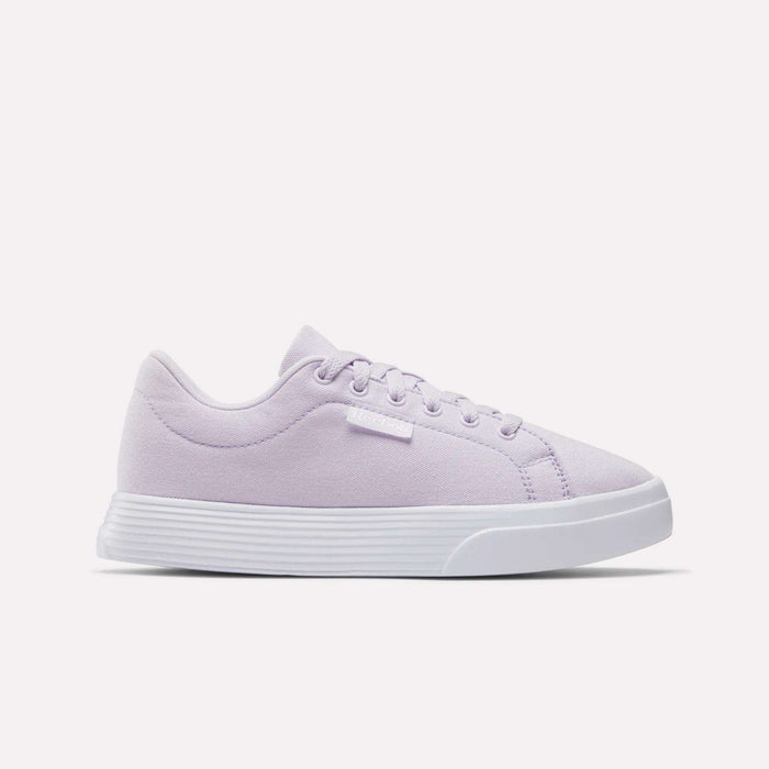 The Reebok Women's OnLux Court Lite Walking Shoes in light purple feature a white sole, white laces, and a small white brand tag. These comfortable sneakers are perfect for all-day wear and are shown on a plain white background.
