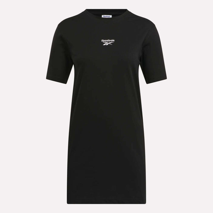 The Reebok Women's Oversized T-Shirt Dress is a plain black, short-sleeve crew neck dress with a small white logo and vector on the chest—ideal for effortless casual style.