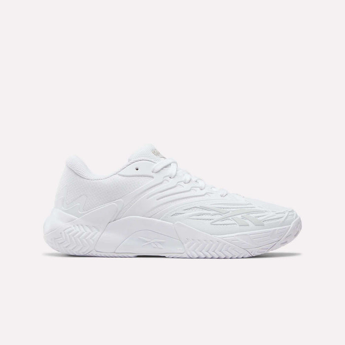 The Women's Phase Evo Tennis Shoes by Reebok are white, low-profile athletic sneakers featuring a textured sole and subtle geometric side patterns, showcased against a plain light background.