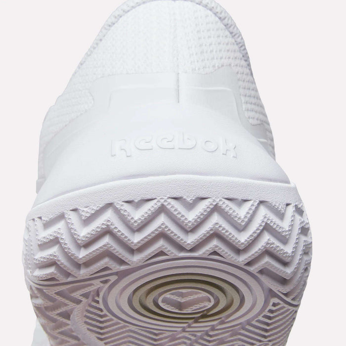 Close-up of the heel and sole of Reebok Women's Phase Evo Tennis Shoes, featuring the Reebok logo on the back and a zigzag tread pattern for durable performance.