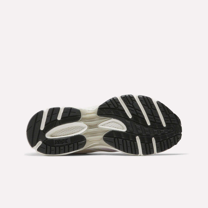 The image displays the black sole with white accents and textured tread of Reebok Women's Premier Trinity Shoes, highlighting their grip-focused design against a plain light background.