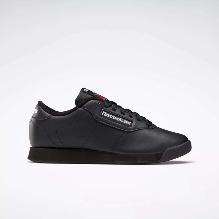 A pair of black Reebok Women's Princess Shoes featuring a classic low design, lace-up closure, heritage accents, and the Reebok logo with Union Jack on the side, displayed against a plain white background.