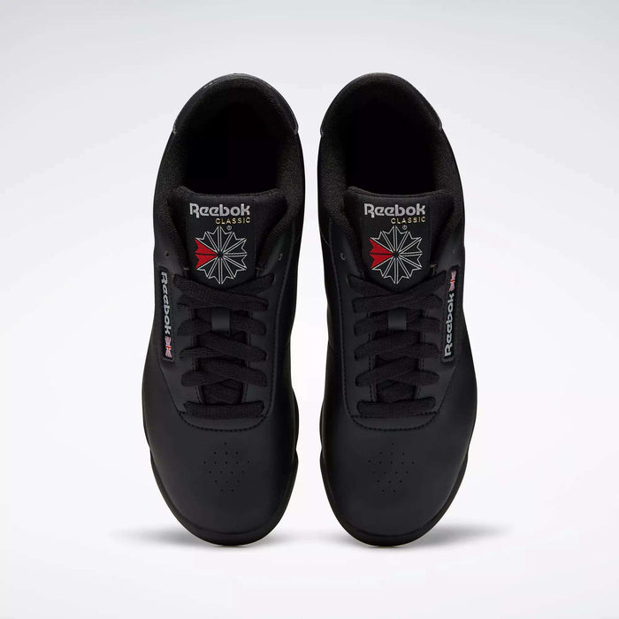 A pair of black Reebok Women's Princess Shoes viewed from above, featuring the Reebok logo and a red and white starburst on each tongue—ideal for those who appreciate heritage style in a classic women’s sneaker.
