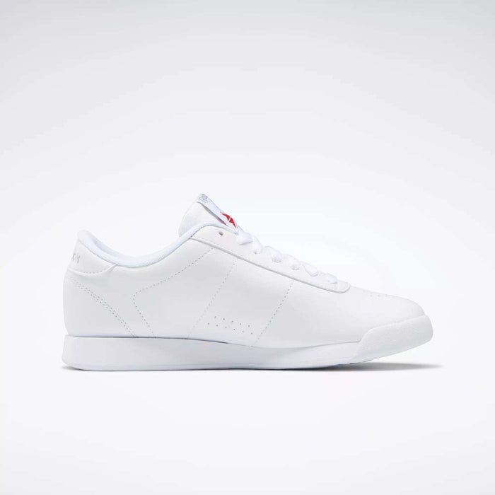 The Reebok Women's Princess Shoes feature a minimalist white design with subtle stitching and white laces, offering timeless heritage style. Shown from the side on a plain white background.