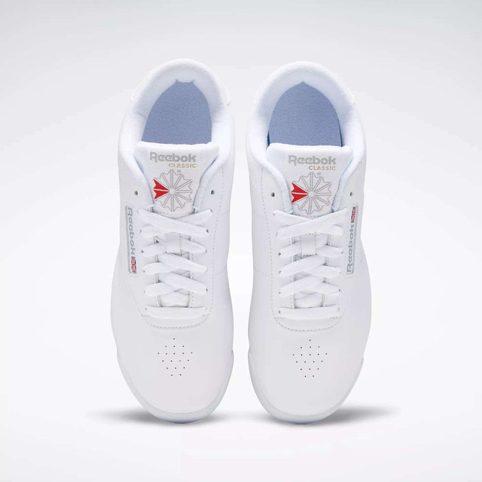 A pair of classic Reebok Women's Princess Wide Shoes with white laces, viewed from above. These sneakers display the Union Jack logo in red and gray on the tongue and side, set against a plain white background.