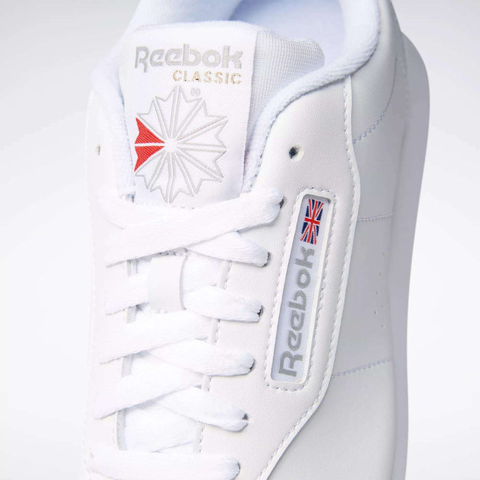 Close-up of a classic women's shoe: the Reebok Women's Princess Wide Shoe in white, featuring signature branding and heritage cushion comfort with neatly tied white laces.