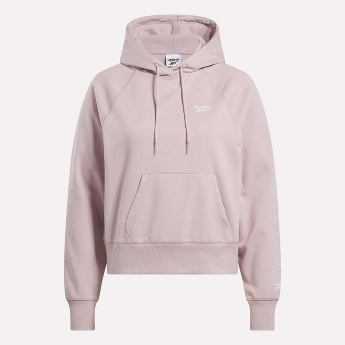 The Women's Small Vector Cropped Hoodie by Reebok comes in light pink French terry, featuring a front pocket, drawstrings, and white logos on the chest and sleeve. Shown against a plain white background.
