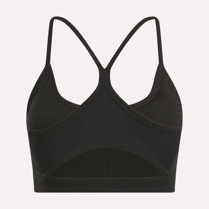 The Reebok Women's Core Strappy Bra offers medium support with thin, crisscrossed racerback straps and a seamless black design—ideal for workouts. Displayed on a plain white background.