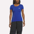 A woman in a fitted Reebok Women's T-Shirt in royal stands against a plain white background.