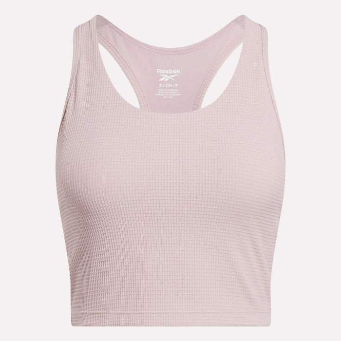 The Reebok Women's Time Out Cropped Tank Top in light pink features a ribbed pattern and racerback design—perfect for stylish activewear. Shown against a plain white background.