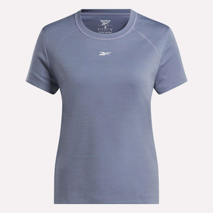 The Reebok Women's Training T-Shirt, shown in light blue with short sleeves and a crew neck, features RBK-DRY technology for comfort. The Reebok logo appears below the neckline against a white background.