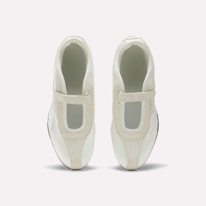 The Reebok Women's Ultra Lo Mary Jane Shoes are white slip-ons with beige accents and a wide elastic top strap, shown from above on a plain white background.