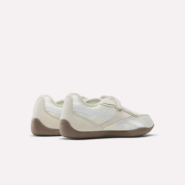 The Reebok Women's Ultra Lo Mary Jane Shoes feature an off-white upper, beige soles, and subtle white details in a low-profile runner style. Shown from the back and side against a plain light background.