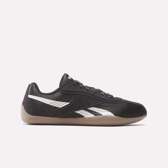 The Women's Ultra Lo Shoes by Reebok feature a black design with signature white Reebok stripes, black laces, and a light brown gum sole. This low-profile sneaker offers sport-inspired style for women. Shown in side view on a plain white background.