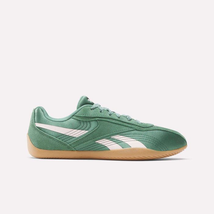 The Reebok Women's Ultra Lo Shoes feature a green low-profile design with white side stripes, lightweight construction, green laces, and a light brown gum sole, displayed in profile view against a white background.