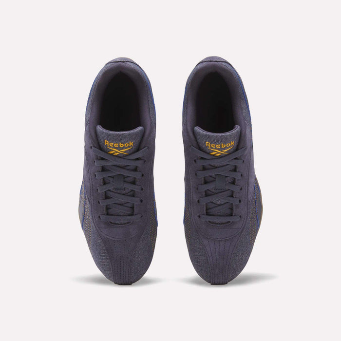 Top view of a pair of Reebok Women's Ultra Lo Shoes in dark purple, featuring yellow Reebok logos on the tongues, set against a white background.