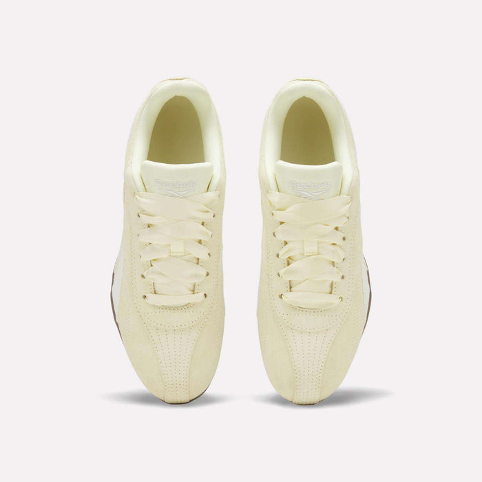 Two cream-colored Women’s Ultra Lo Shoes by Reebok, shown from above, showcase a suede upper, classic laces, rounded toes, and perforated details on the toe area, all set against a plain white background.